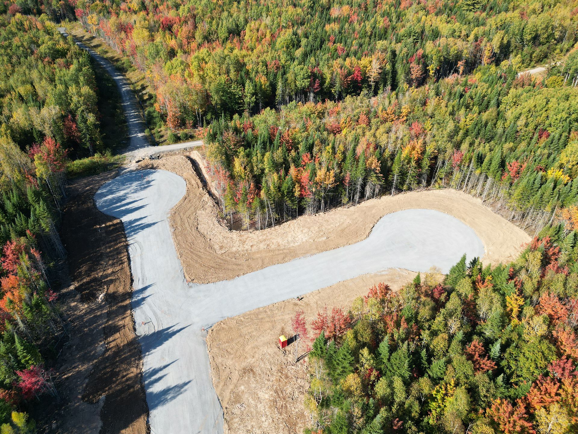 An aerial view of a road in the middle of a forest.