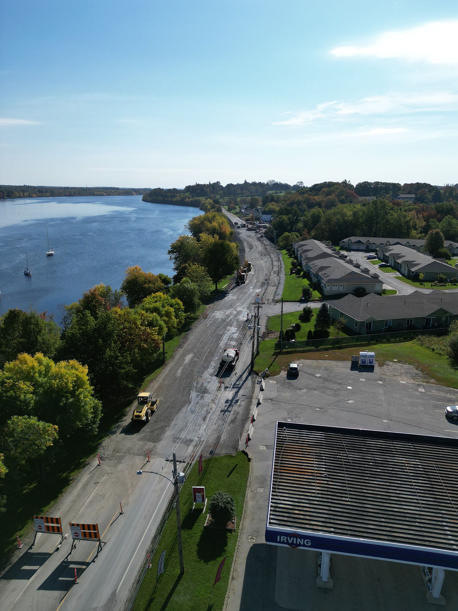 An aerial view of a gas station next to a body of water