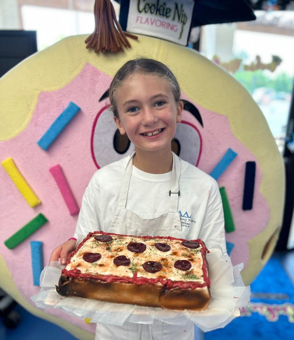 A person smiles while holding a rectangular 