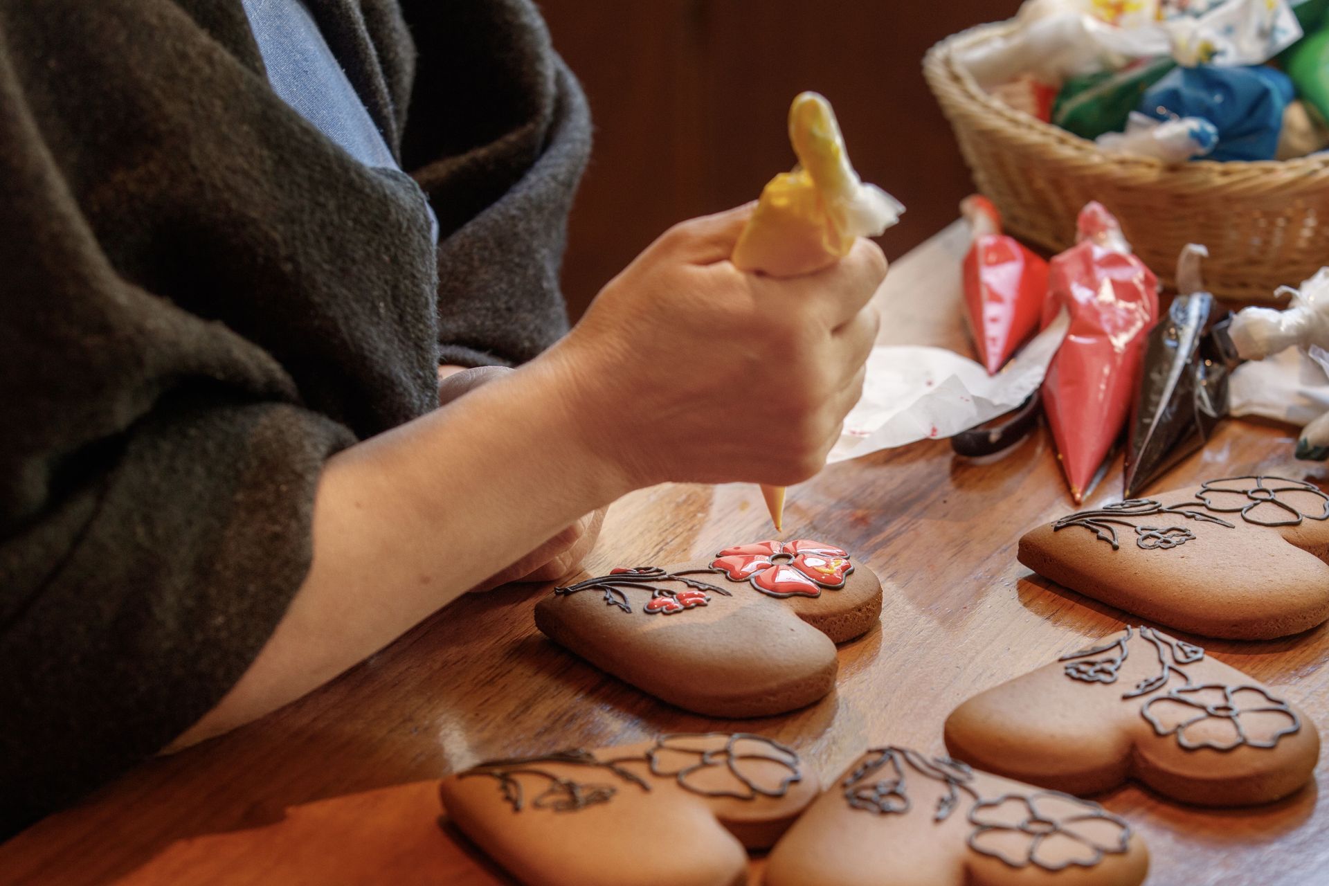 Person decorating gingerbread cookies with frosting.