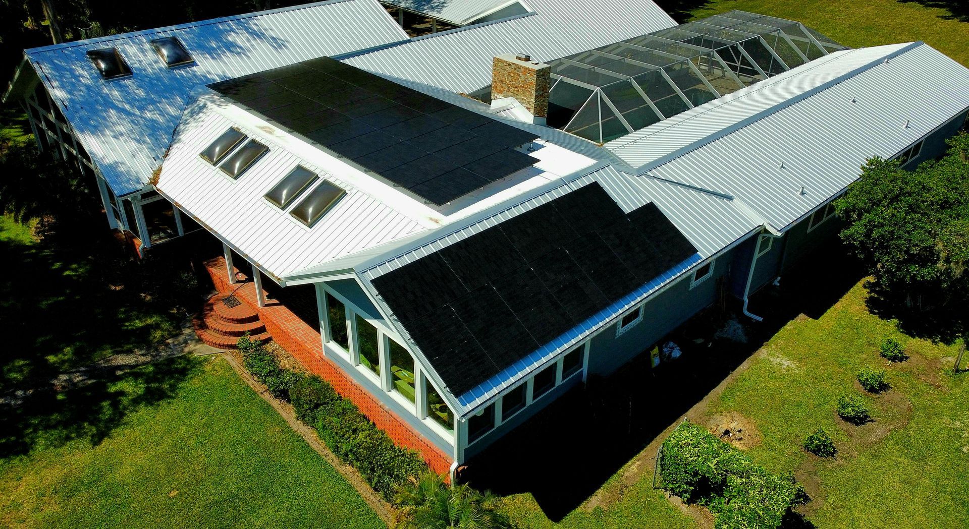 An aerial view of a house with solar panels on the roof