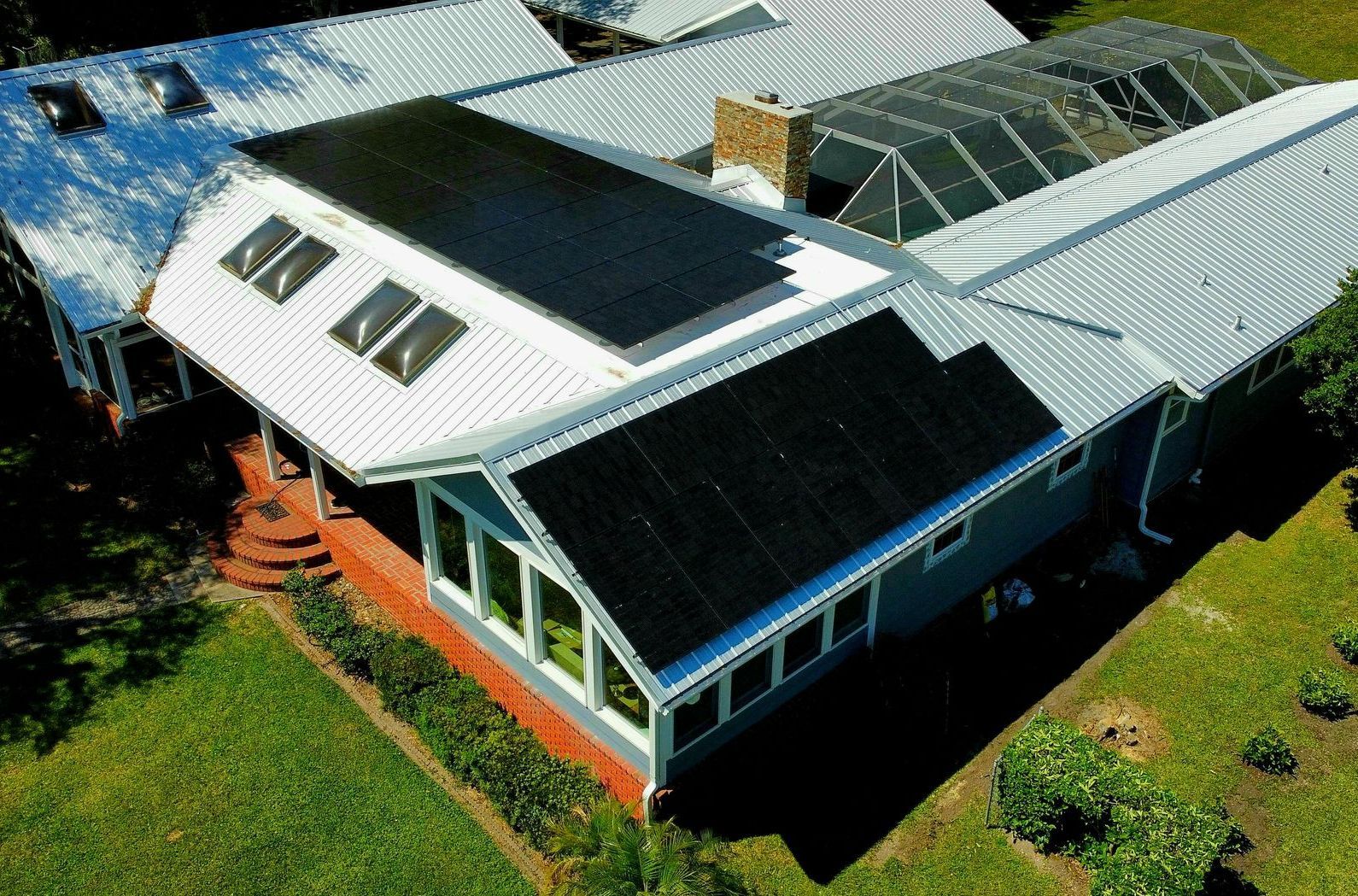 An aerial view of a house with solar panels on the roof