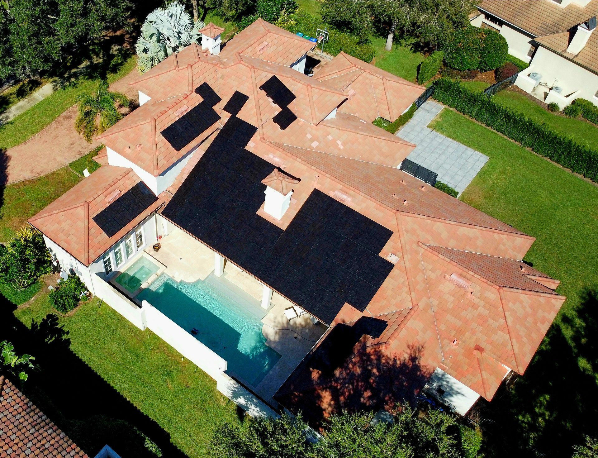 An aerial view of a house with a pool and solar panels on the roof