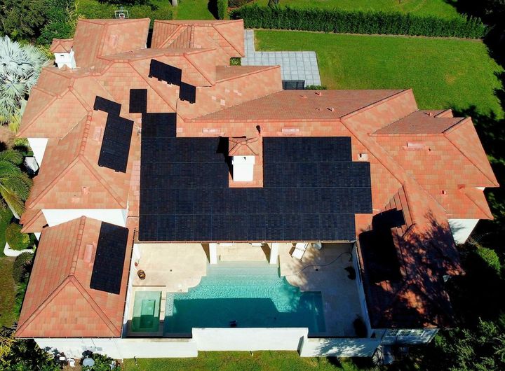 An aerial view of a house with solar panels on the roof