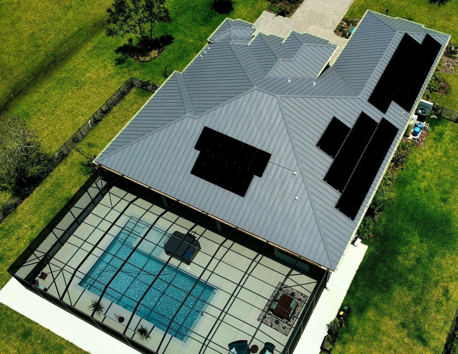 An aerial view of a house with a pool and solar panels on the roof