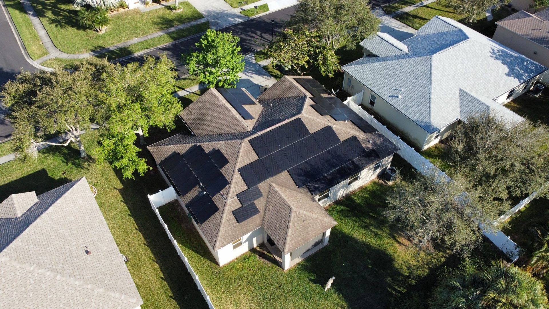 An aerial view of a house with solar panels on the roof.