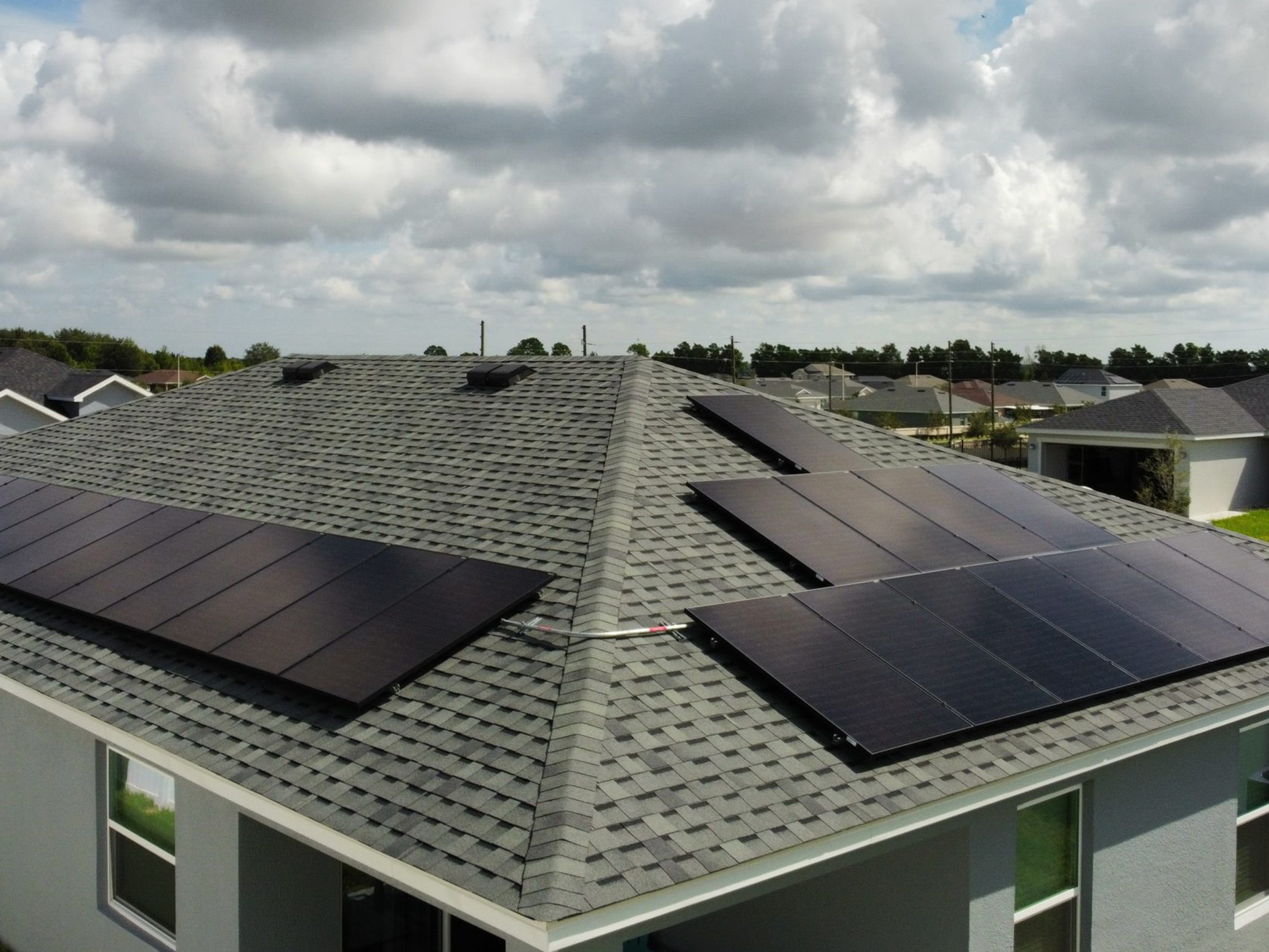 An aerial view of a house with solar panels on the roof
