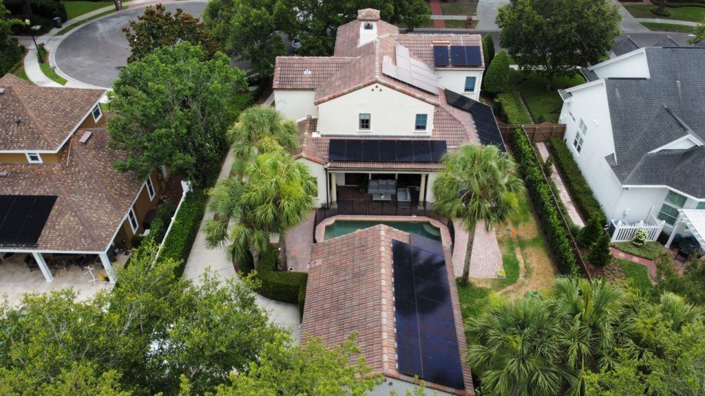 An aerial view of a house with a pool and solar panels on the roof.