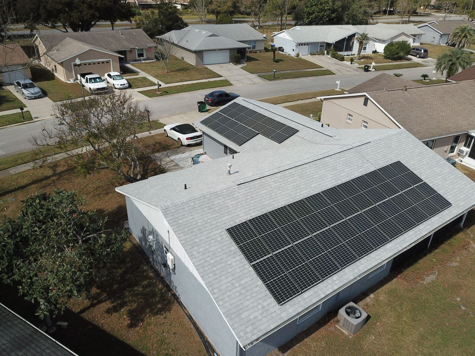 An aerial view of a house with solar panels on the roof.