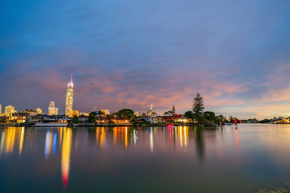 A City Skyline Is Reflected in A Lake at Night — Goldspark GC Electrical in Bundall, QLD
