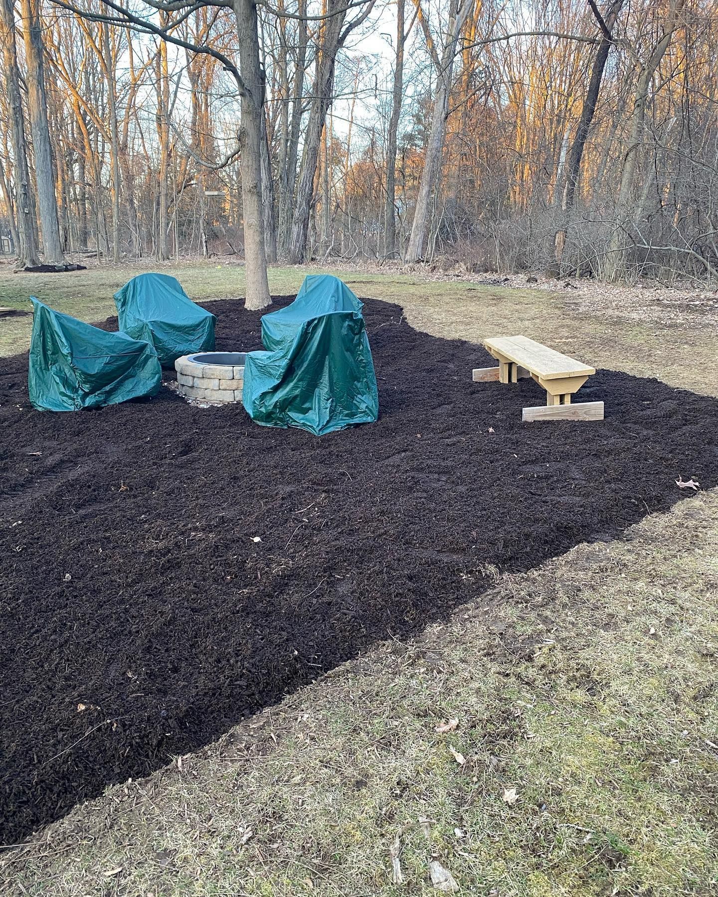 A picnic table is sitting in the middle of a pile of mulch.