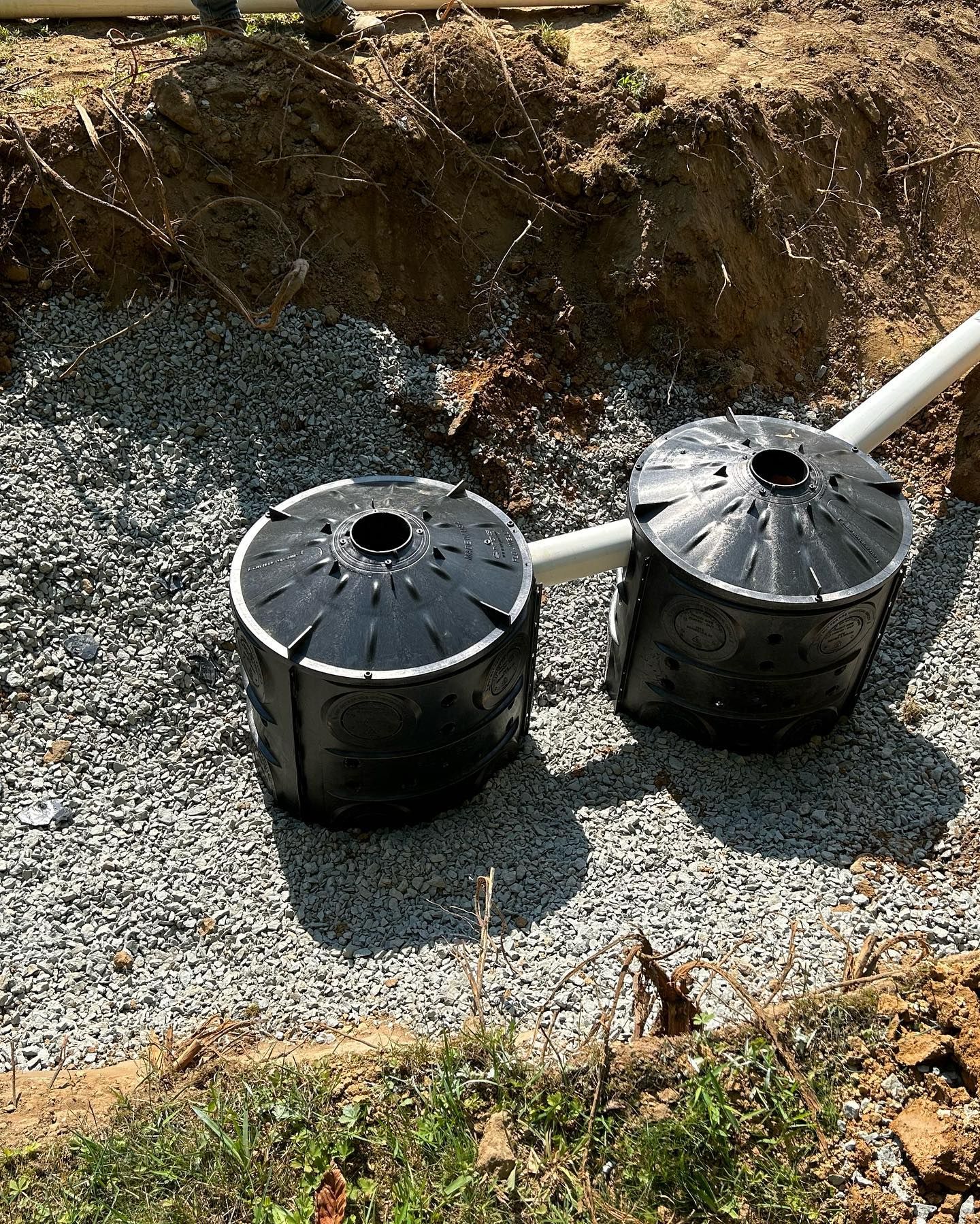 A couple of barrels sitting on top of a pile of gravel.