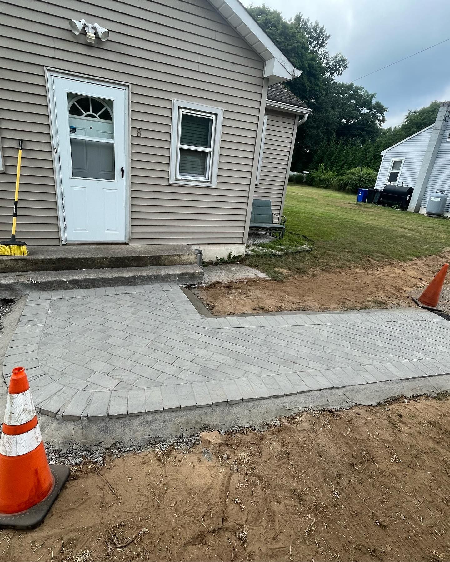 A concrete walkway is being built in front of a house.