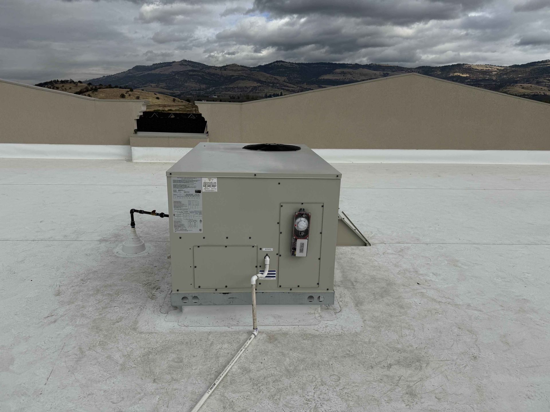Military-trained HVAC expert Justin from Trademark Tech servicing commercial heating system in Southern Oregon business facility