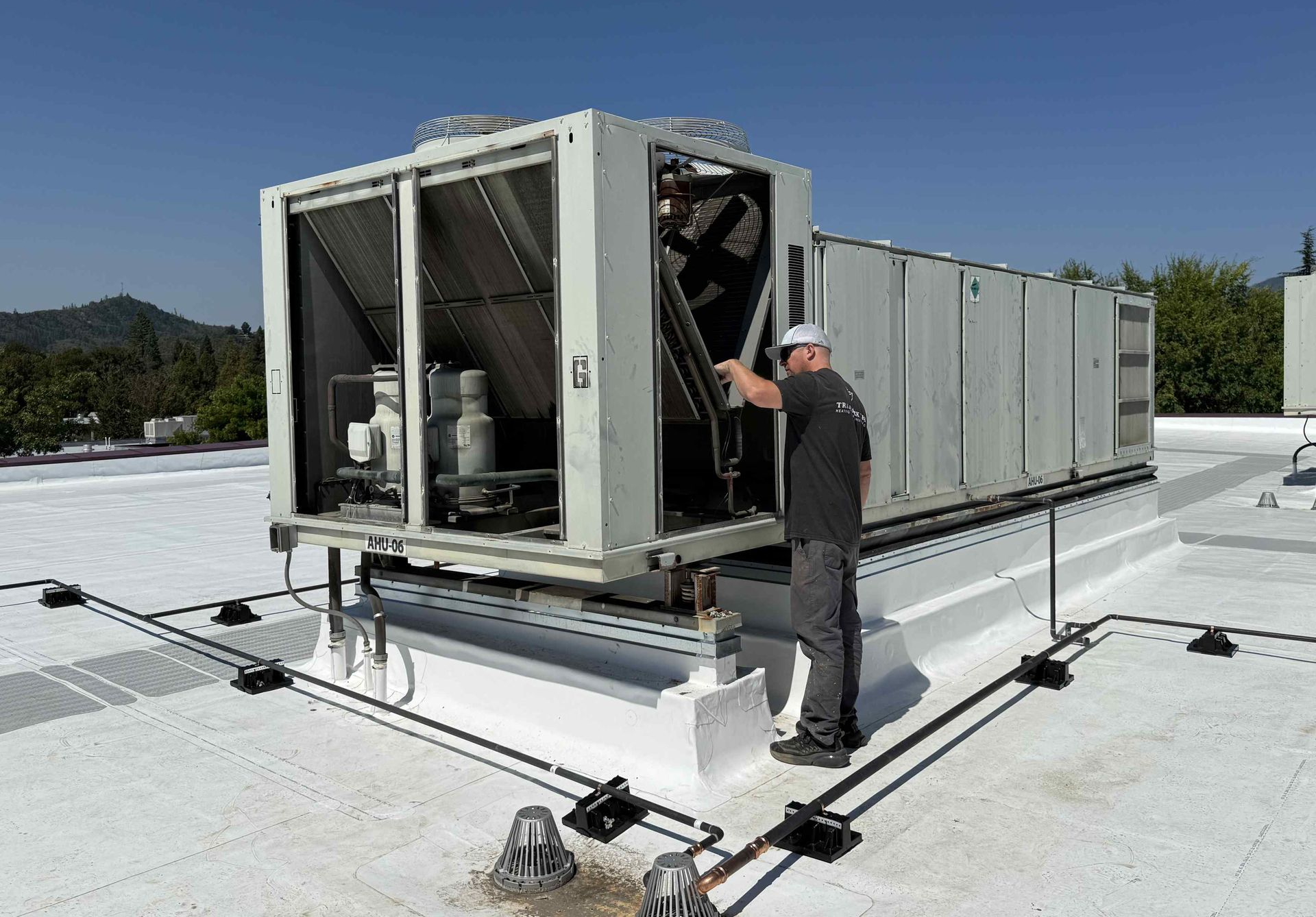 Military-trained HVAC expert Justin from Trademark Tek repairing a complete commercial HVAC system in Southern Oregon business facility