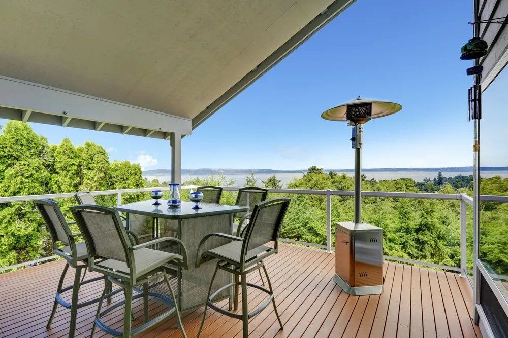 A Deck with A Table and Chairs and A Heater on It — Manning Valley Patios in Cundletown, NSW