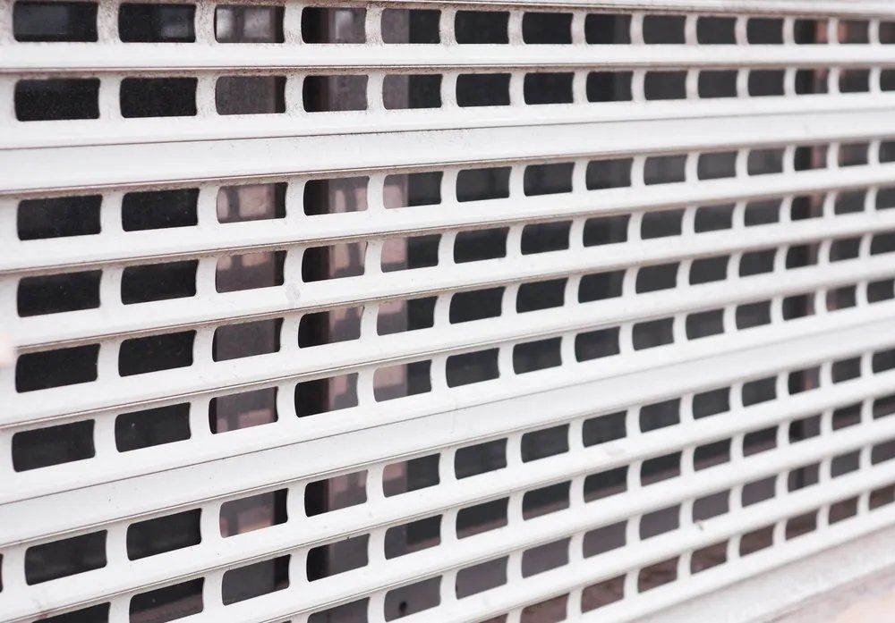 A Close up Of a White Roller Shutter with Black Squares on It — Manning Valley Patios in Old Bar, NSW