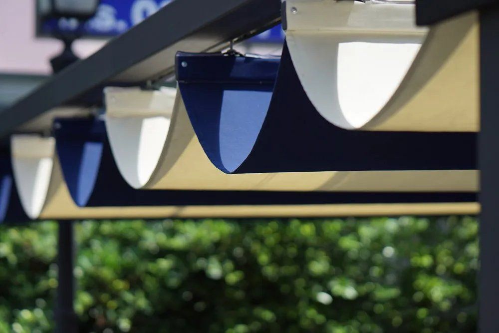 A Blue and White Awning Is Hanging from A Pole — Manning Valley Patios in Cundletown, NSW