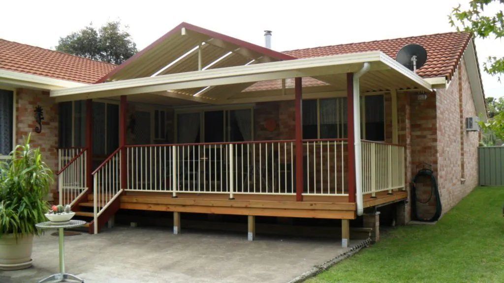 A Brick House with A Wooden Deck and Stairs — Manning Valley Patios in Cundletown, NSW