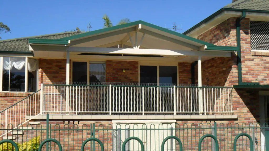 A Brick House with A Balcony and A Green Roof — Manning Valley Patios in Cundletown, NSW