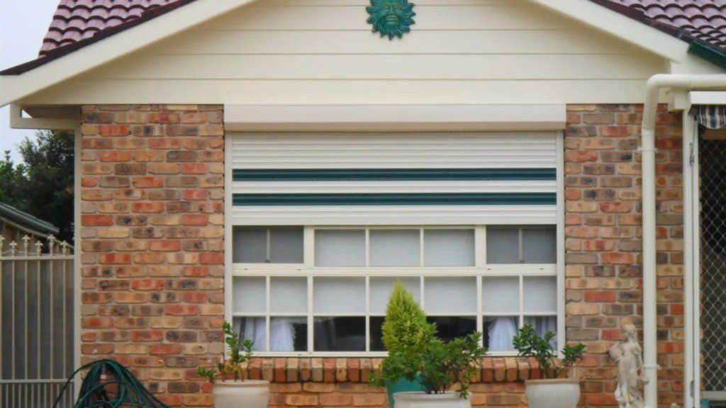 A Brick House with A White Shutter on The Window — Manning Valley Patios in Cundletown, NSW