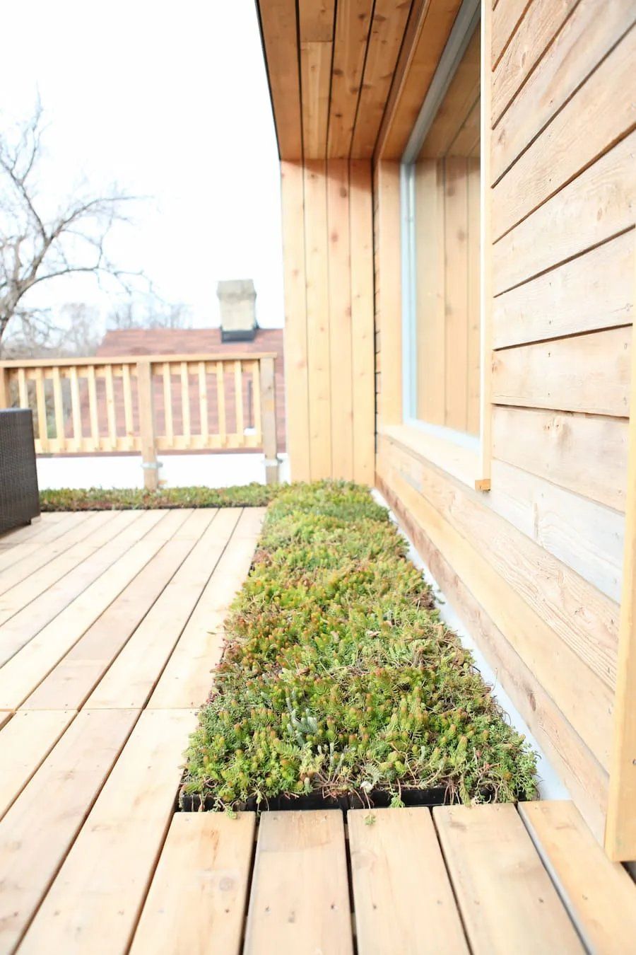 A Wooden Deck Next to A House with A Window — Manning Valley Patios in Harrington, NSW