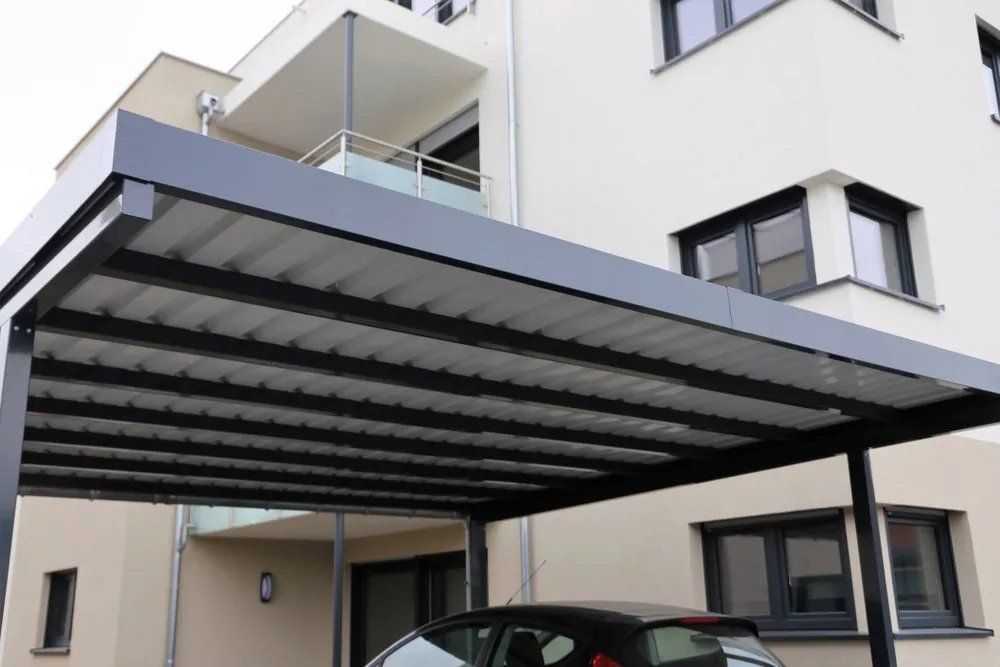 A Car Is Parked Under a Carport in Front of A Building — Manning Valley Patios in Wingham, NSW