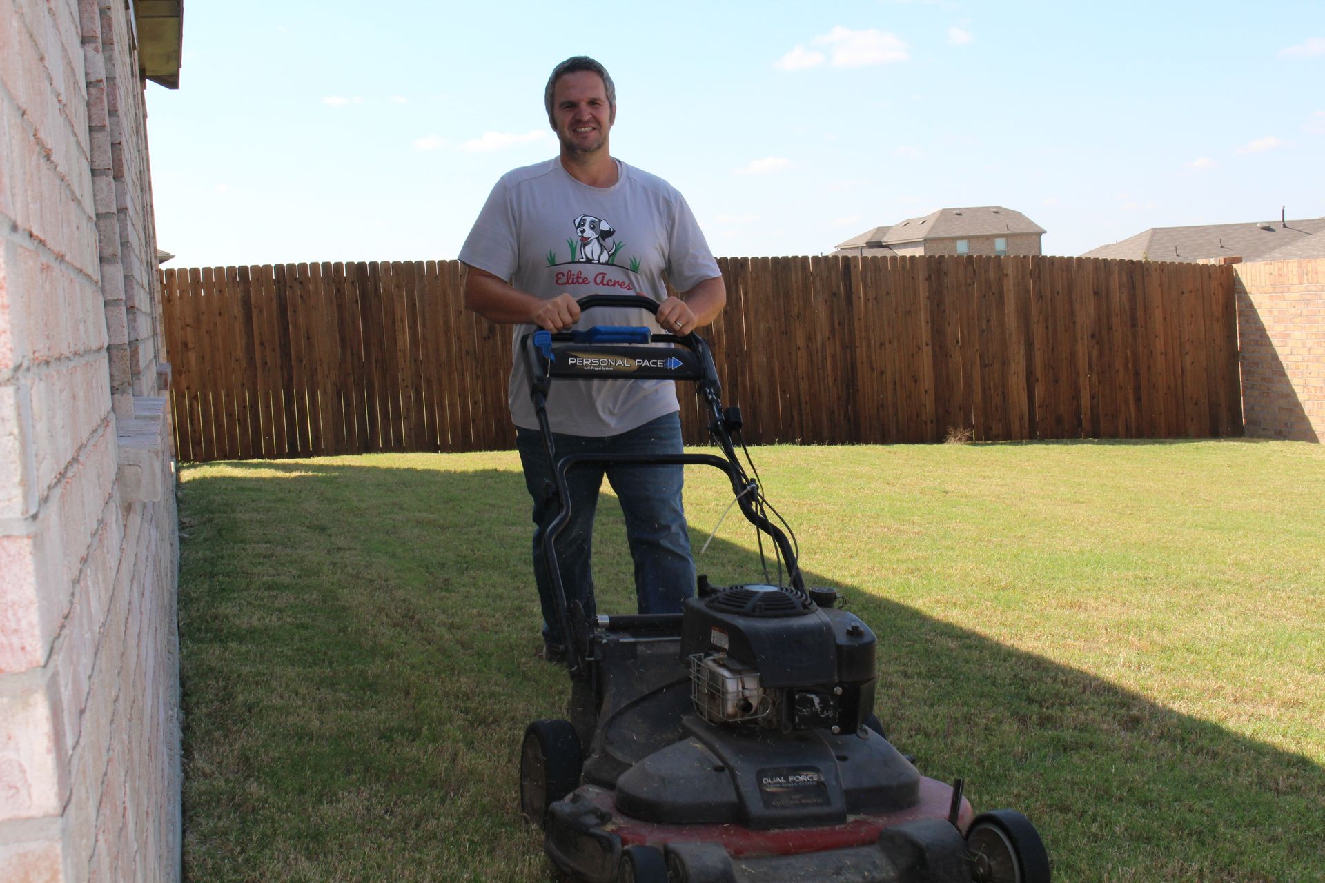 A man mowing the backyard.