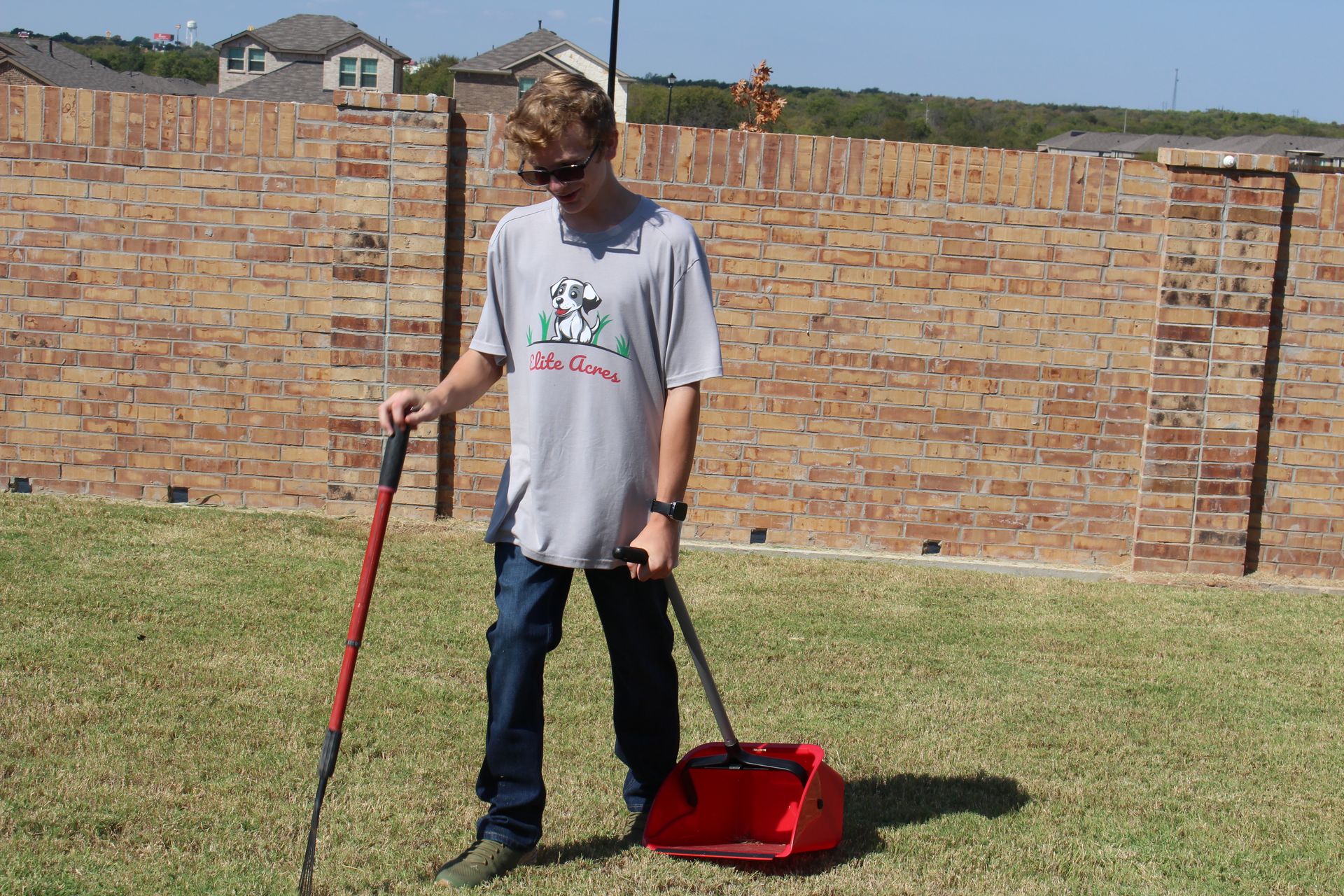 A young man picking-up the dry leaves.