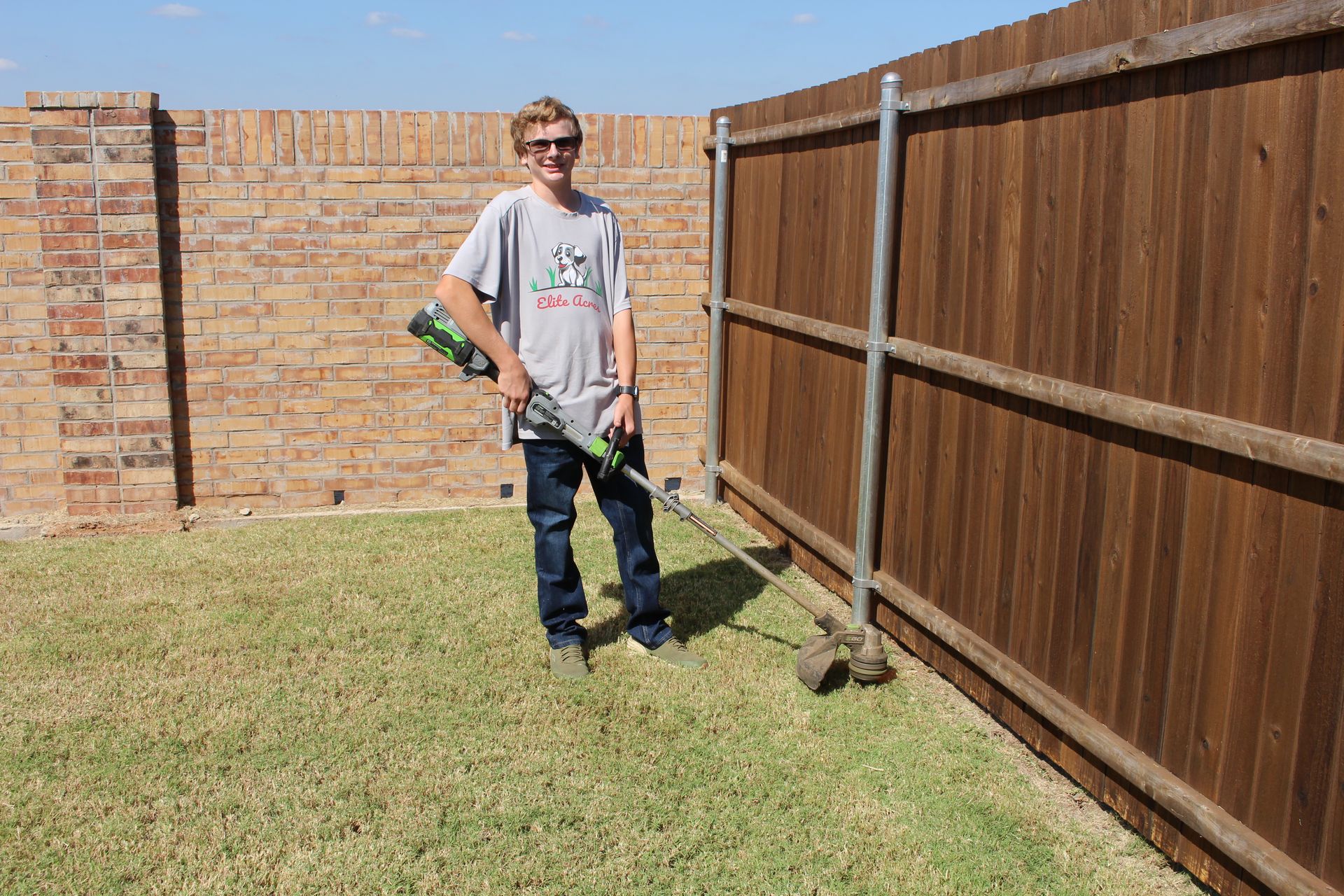A young man is using a grass cutter.