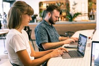 Image of a male and female sitting next to each other working on laptops symbolizing Engineering and Project Management