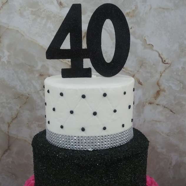 Black-and-white birthday cake with a large “40” topper against a marble background