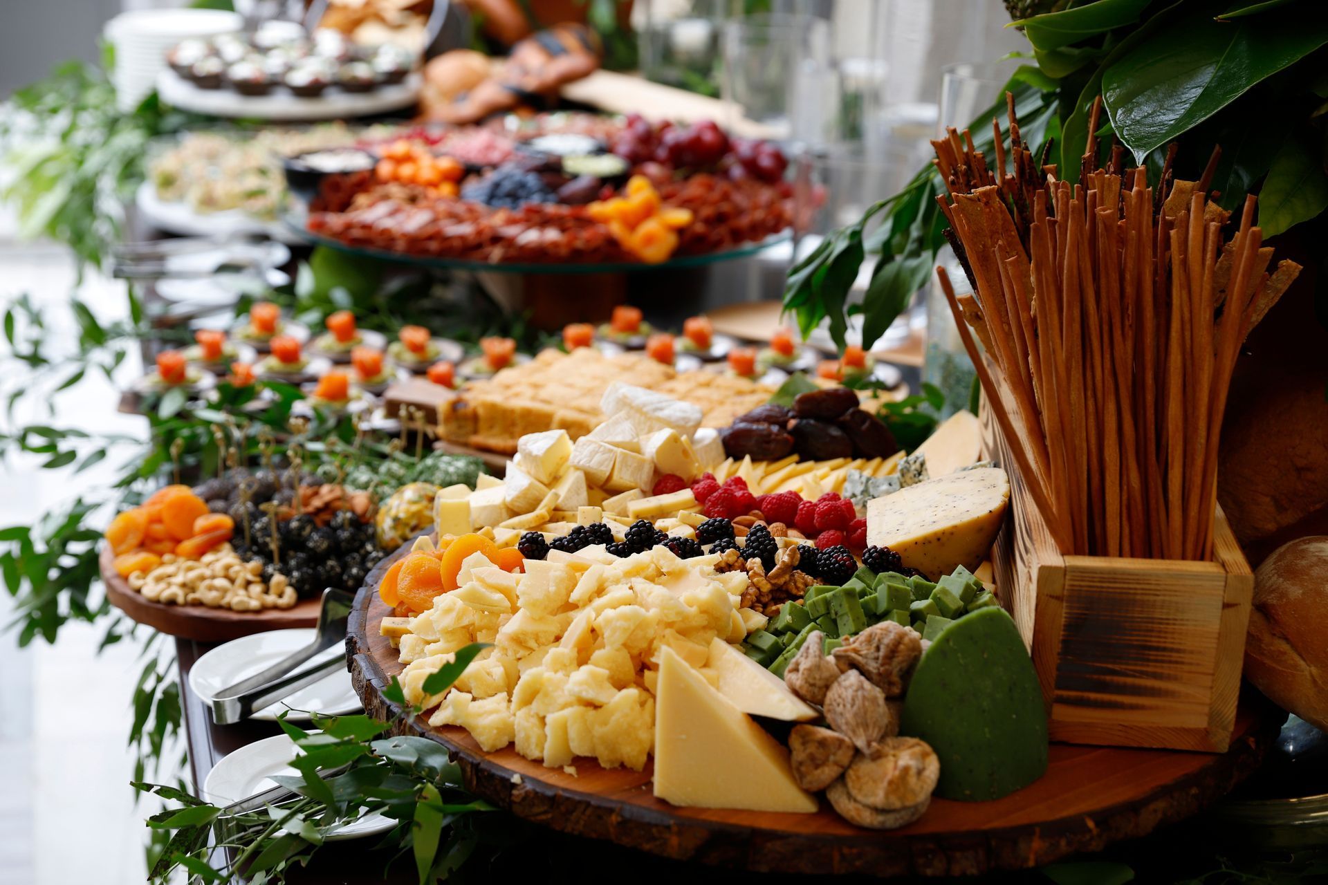 Buffet table with assorted cheeses, fruit, and appetizers at a catered event