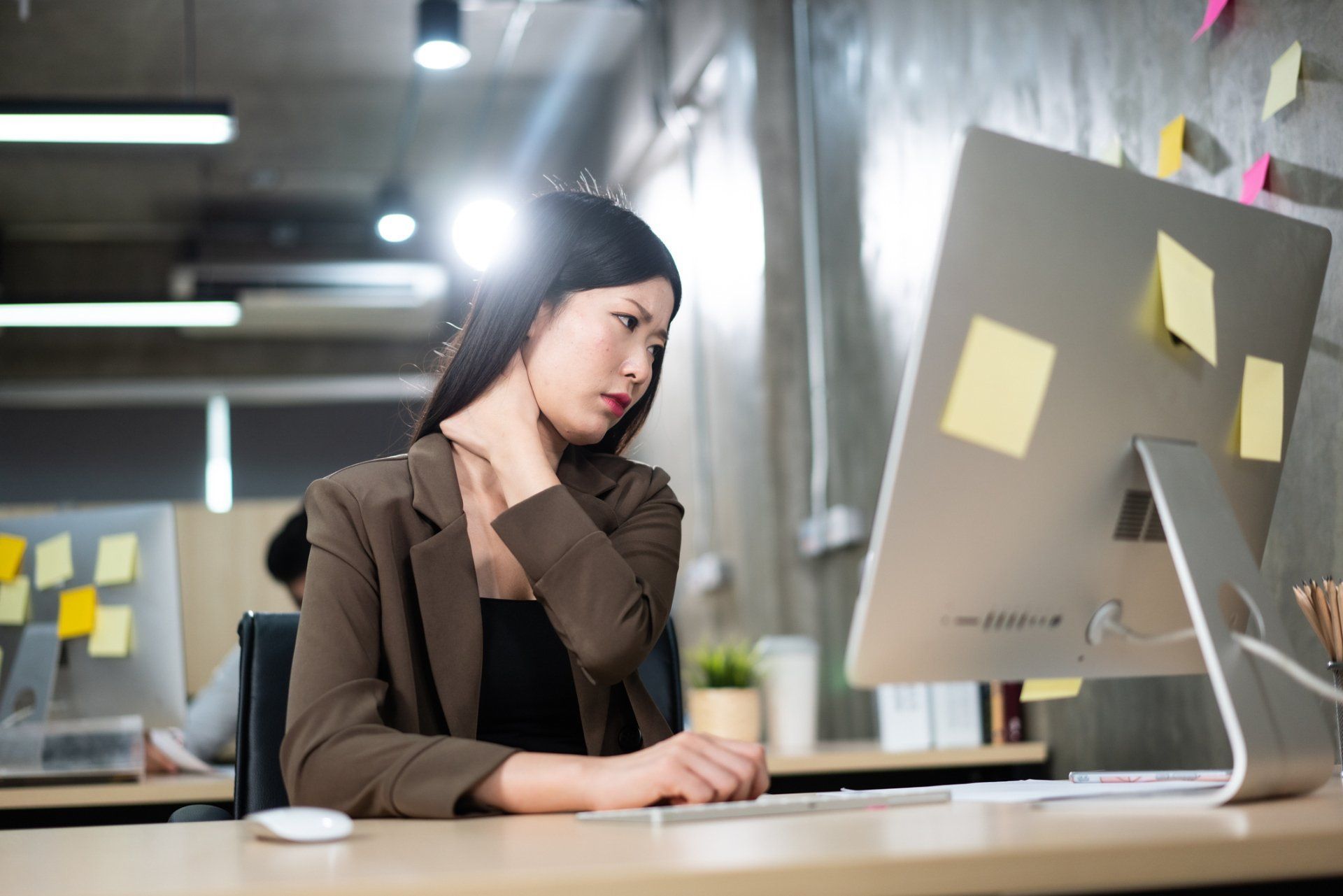 Office assistant in front of computer with nape aching | Colorado Springs, CO | The Partridge Family Practice