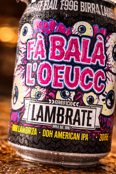 Beer can label reading “FA BALÀ L’OEUCC” with “LAMBRATE” on a colorful background.