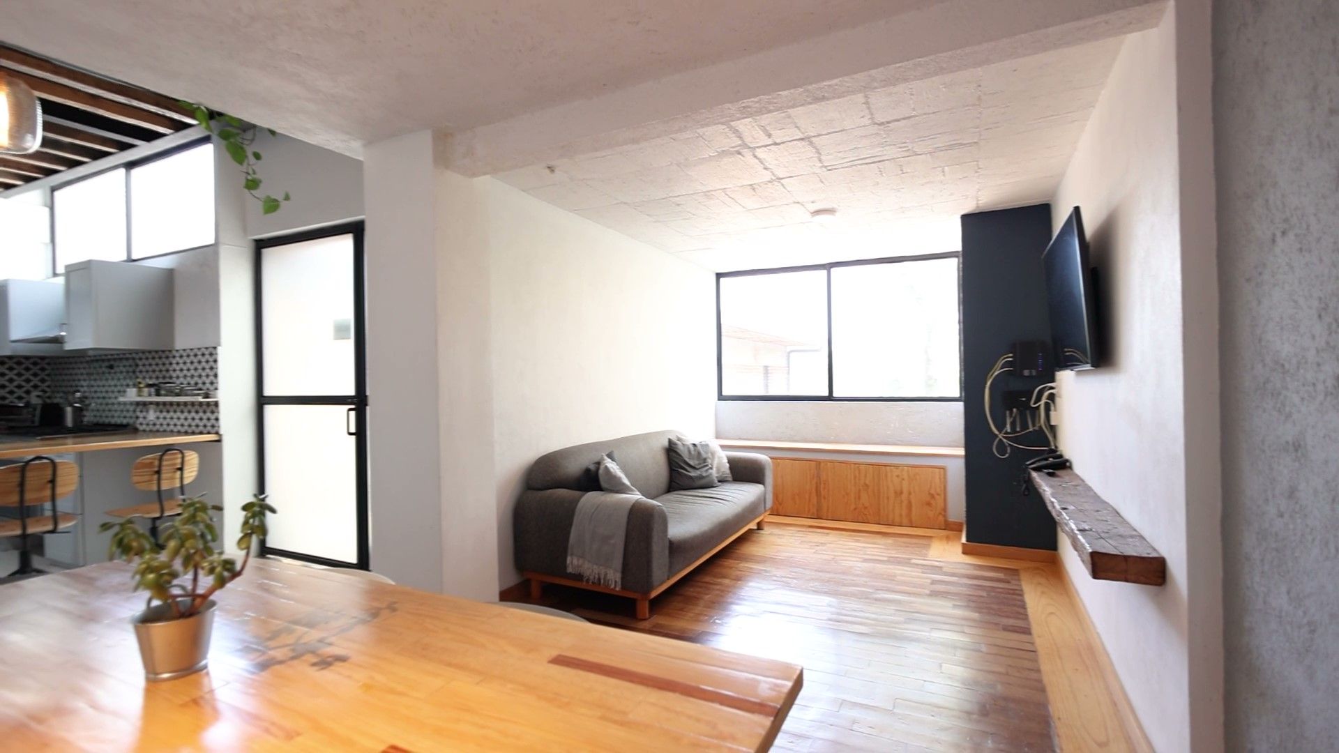 Una sala de estar con sofá, mesa y televisión.