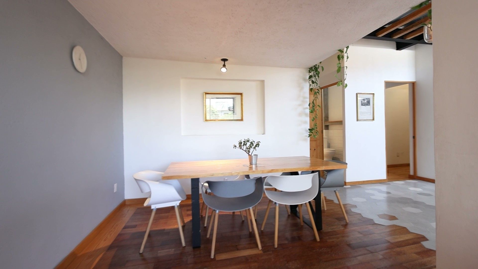 Un comedor con una mesa y sillas y un reloj en la pared.