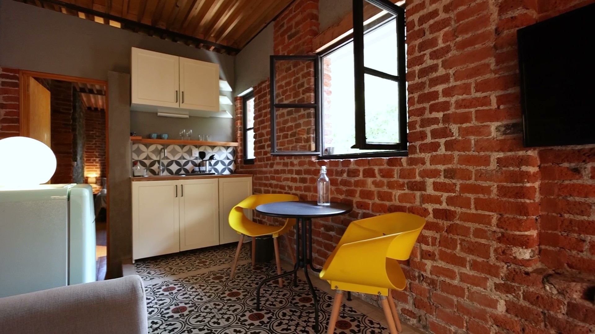 Una sala de estar con una mesa y sillas y una pared de ladrillos.