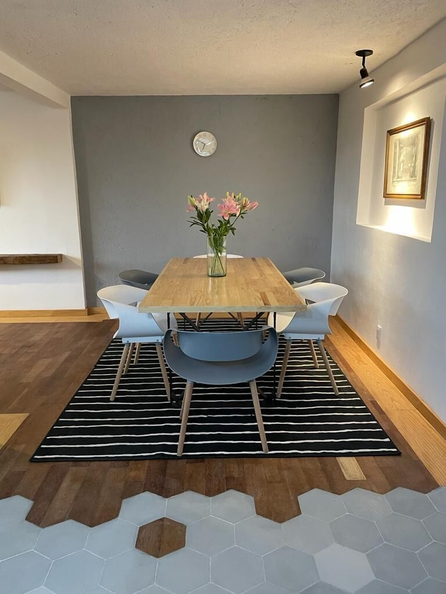 Un comedor con una mesa y sillas y una alfombra.