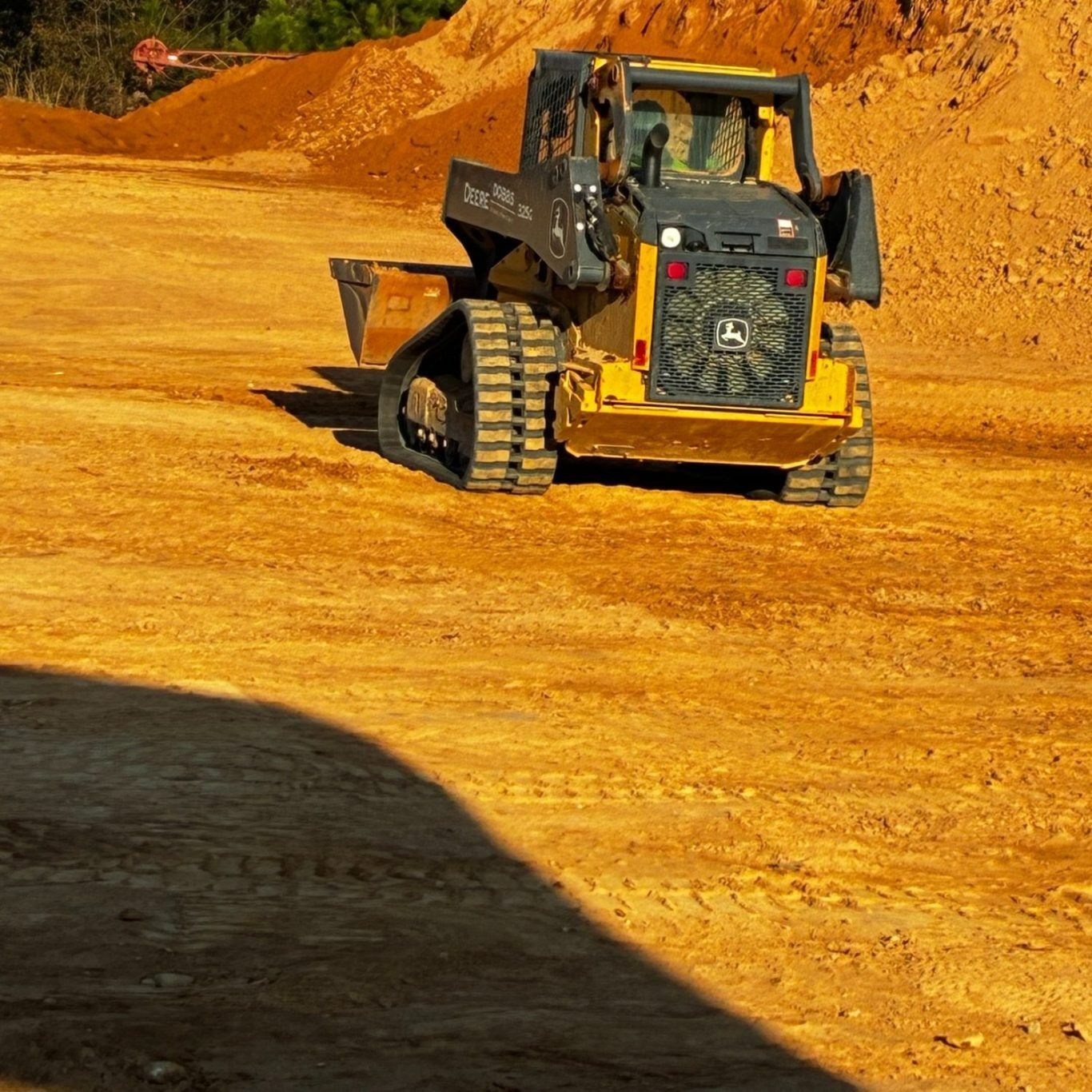 Yellow bulldozer working on a dirt construction site under bright sunlight