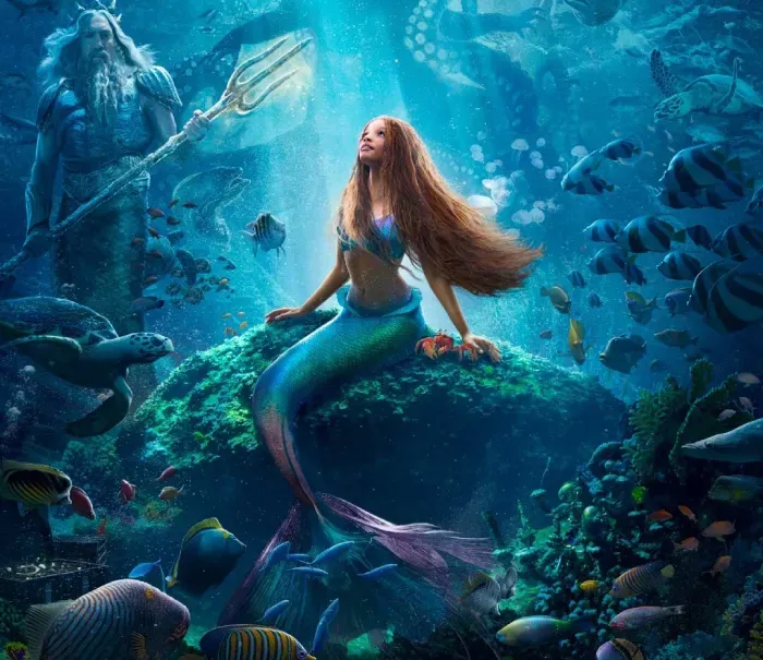 Mermaid on a rock in a glowing underwater scene, with a trident-bearing sea figure and fish around her