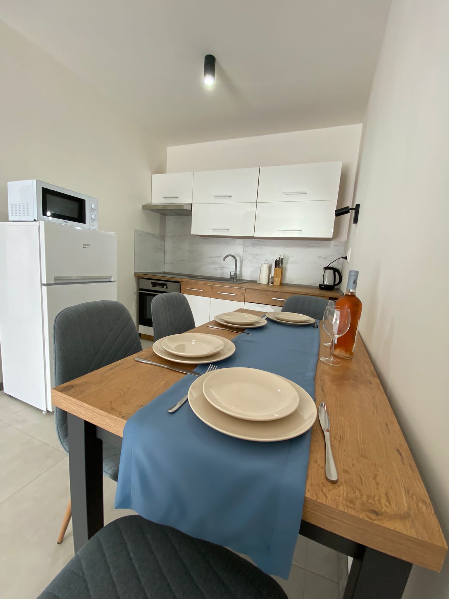 Záber na jedálenský stôl a kuchyňu v apartmáne 1