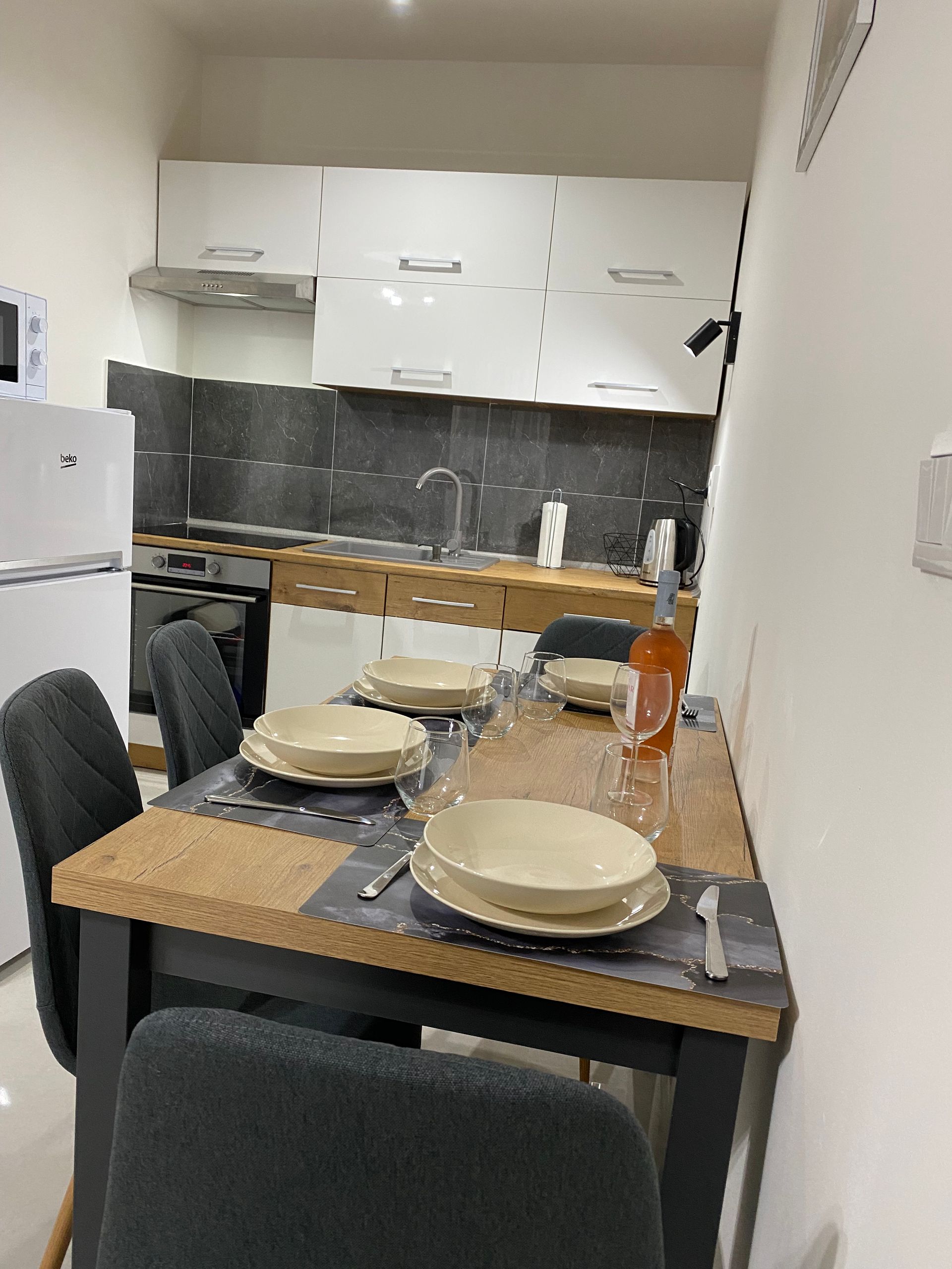 Záber na jedálenský stôl a kuchyňu v apartmáne 2