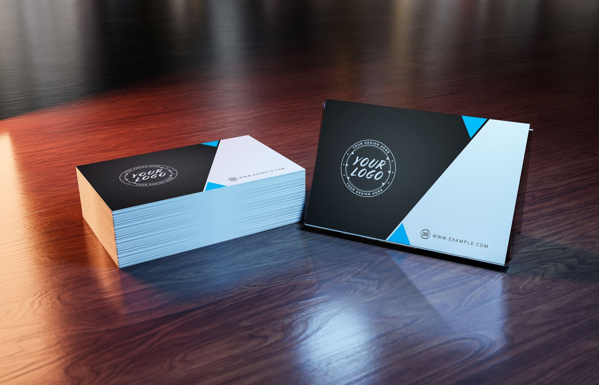 Stack of black and white business cards with a logo and light blue accents on a wooden surface.