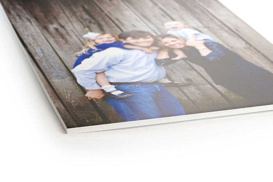 Family portrait printed on a rigid board, with a dad carrying a child, smiles.