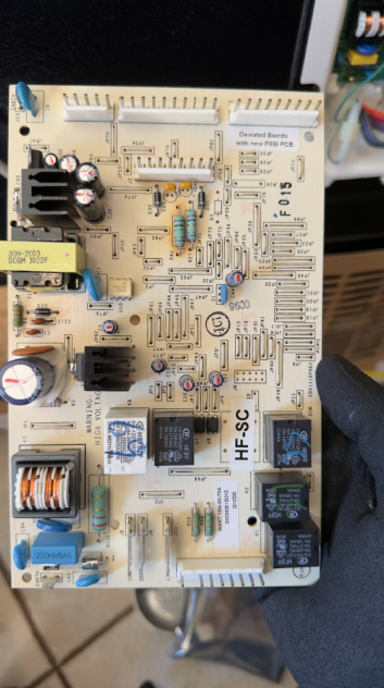 Electronics circuit board with relays, capacitors, and connectors on a work surface