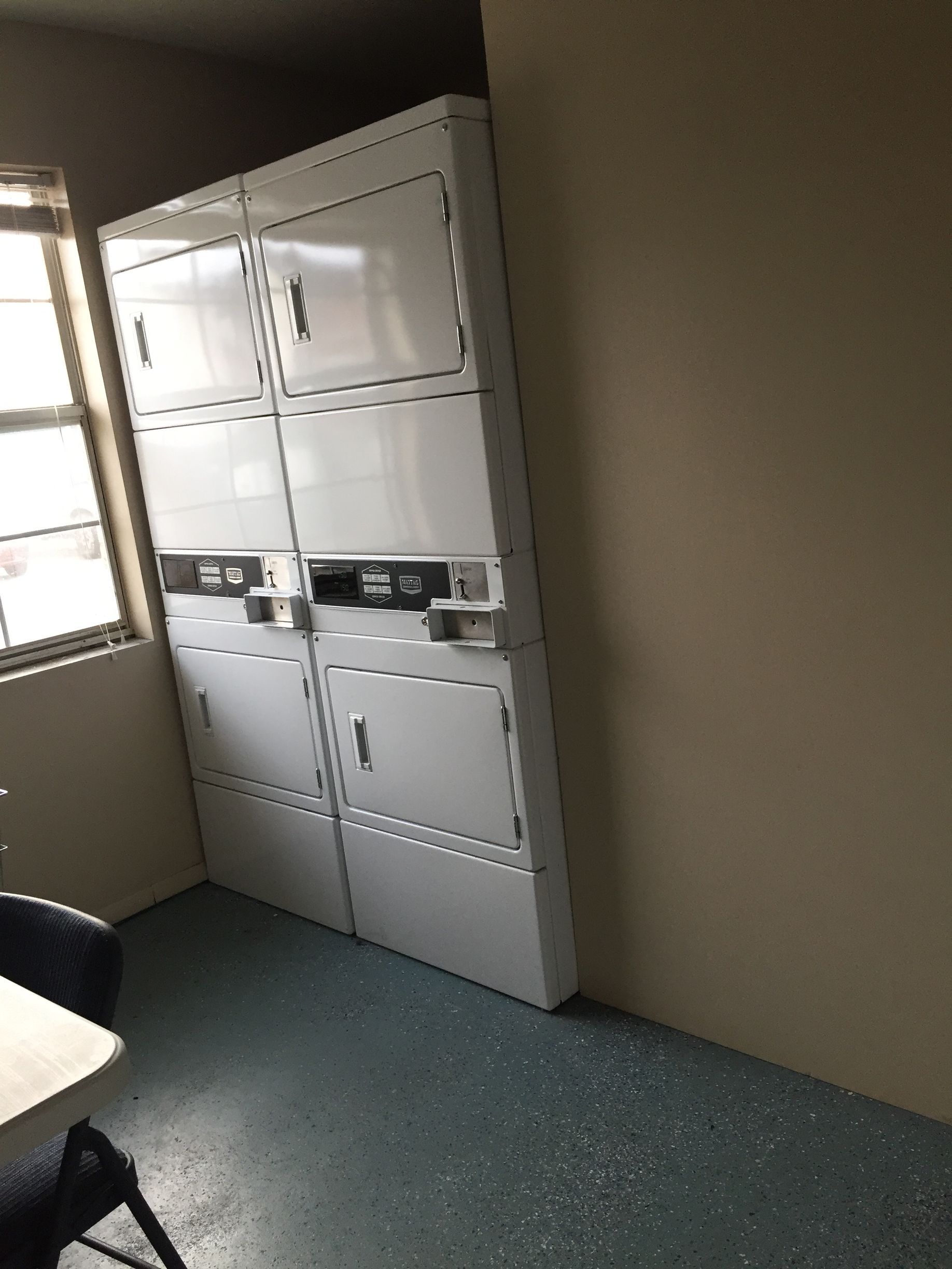 A laundry room with a stack of washers and dryers