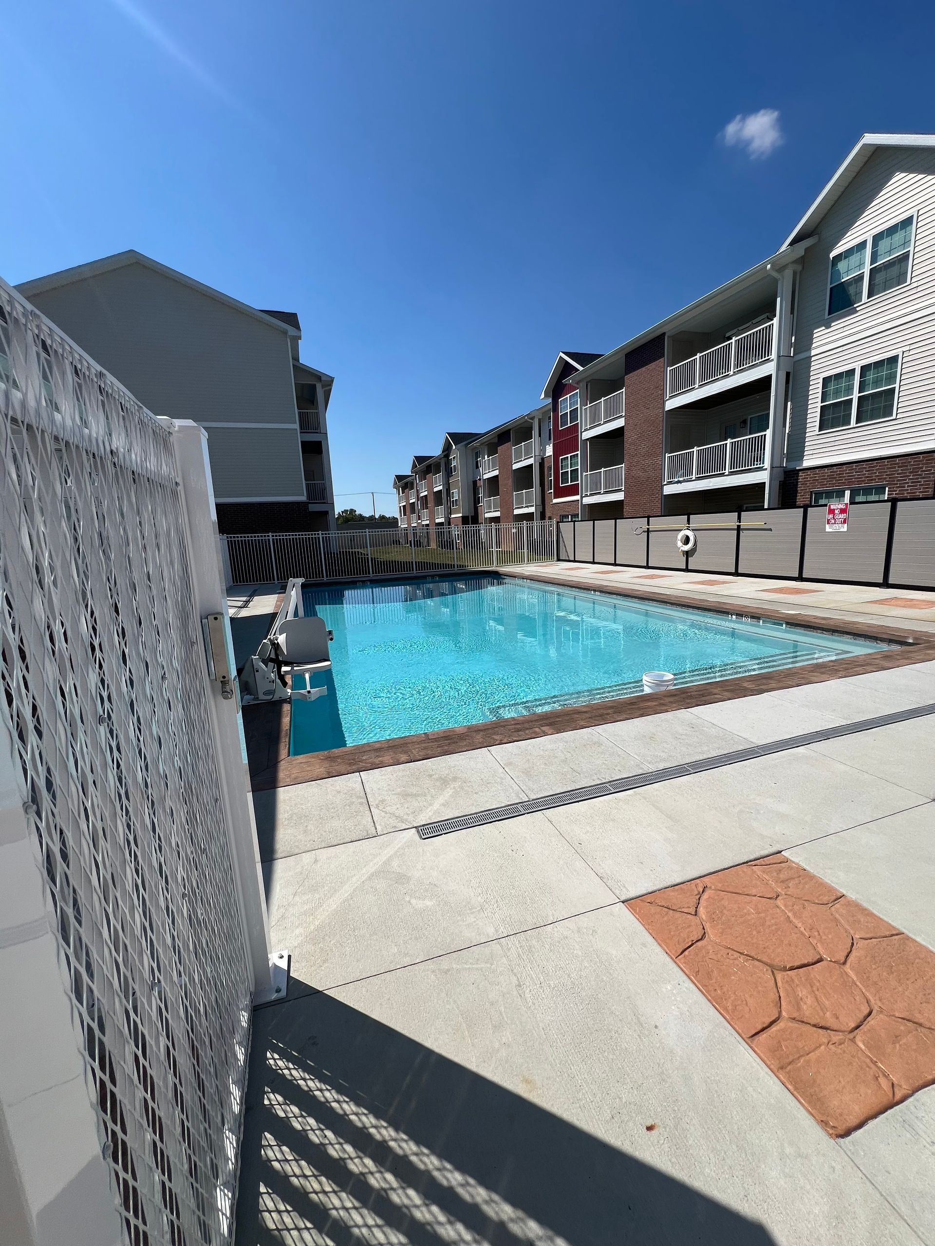 A large swimming pool surrounded by buildings on a sunny day
