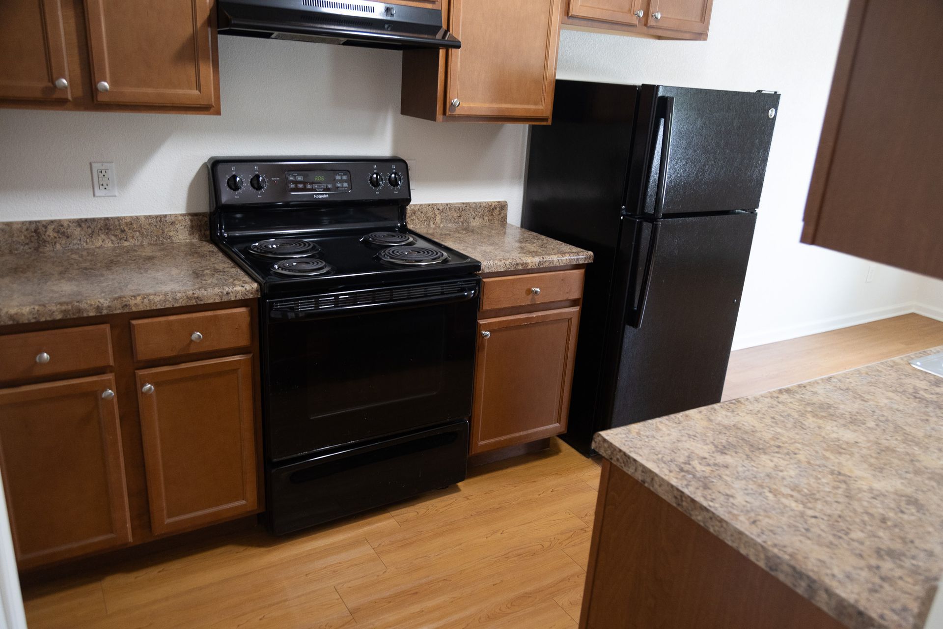 A kitchen with a black stove and a black refrigerator