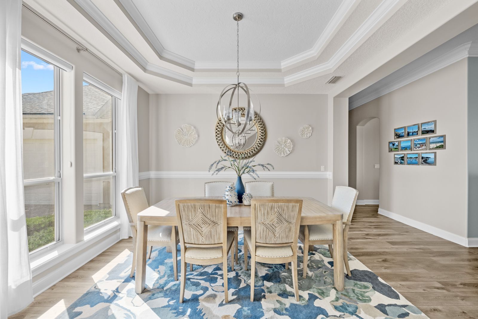 A dining room with a table and chairs and a rug.